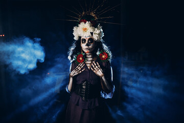 Woman with mexican skull halloween makeup on face. Day of the dead aka Dia de los Muertos and halloween concept.