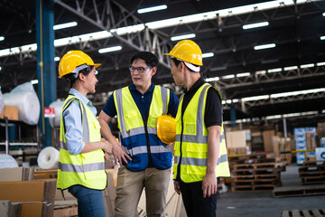 Asian warehouse workers team talk about Inventory check and product delivery in retail warehouse full of shelves with goods. teamwork at warehouse storage department.