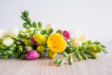 Bouquet of spring freesia flowers on wooden table