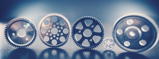 Different shapes cogwheels standing on the black background.