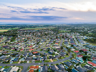 Aerial view over suburbia - streets and homes in country town at dusk