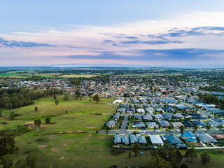 Drone view over edge of suburbia to countryside edge of urban development