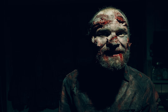 Zombie man portrait in darkness with makeup for halloween party