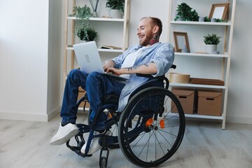 Man in wheelchair freelancer working at laptop at home smile, work online, movement restriction,...
