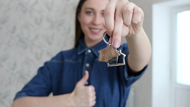 Happy woman showing the keys to a new apartment or house.