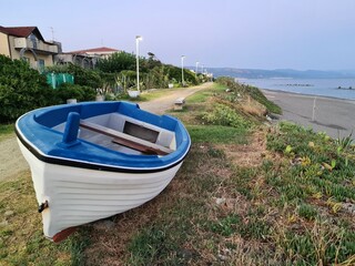Fototapeta premium evocative close-up image of a fishing boat pulled ashore at the sea in a small fishing village in Sicily, Italy