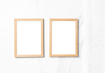 Two mockup wooden frames on white table with white towel.