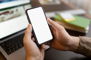 Man hand holding mobile phone using application shopping online, looking at blank display. Mockup. Male ordering food, communication, chatting, selective focus. Technology concept 