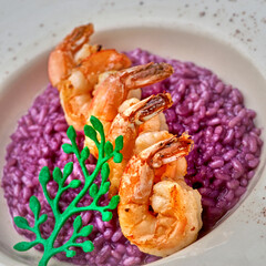 Delicious Italian risotto with grilled big tails of shrimp. Pink risotto. Healthy tasty food.