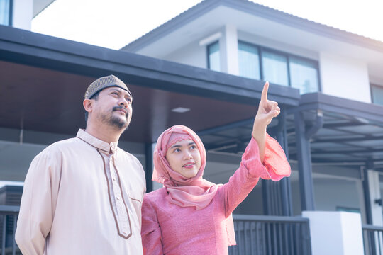 Happy muslim family standing at new home