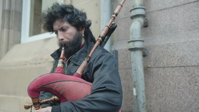 A street performer playing a set of bagpipes