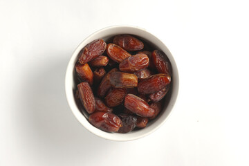 a bowl filled with a collection of dates with a plain white background