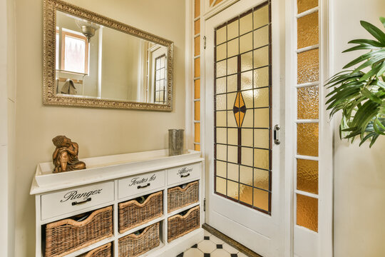 An Entry Way With Baskets On The Floor And A Large Mirror Hanging Over The Front Door To The Entranceway