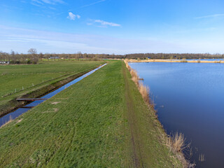 Fototapeta na wymiar aerial shot above oldambt early spring with sunny wheater with lake, water and blue sky