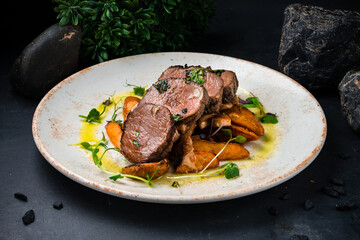 Beef medallions with mushroom sauce and fried potato wedges.