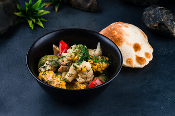 Fresh chicken stew with cauliflower, corn, zucchini, bell peppers, onions, herbs and tortilla.