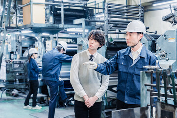 工場を見学する男子学生