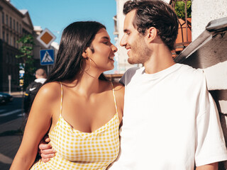 Smiling beautiful woman and her handsome boyfriend. Happy cheerful family. Sexy couple posing in the street at sunrise. During romantic date at sunny summer day outdoors. Looking at each other