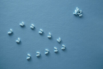 Fototapeta na wymiar Pharmaceutical nutraceutical medicine blue tablets spilled on blue background