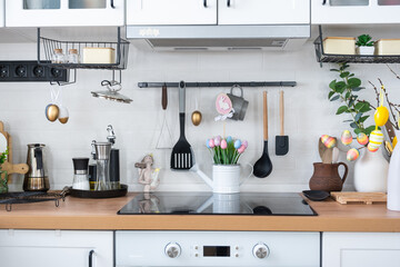 Interior of kitchen and details of decor of utensils with Easter decoration of colorful eggs in a loft style. Festive interior of a country house