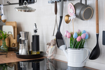 Interior of kitchen and details of decor of utensils with Easter decoration of colorful eggs in a...