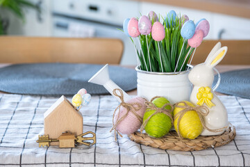 Key to house of cozy home with Easter decor with rabbit and eggs on table of kitchen. Building, design, project, moving to new house, mortgage, insurance, rent and purchase real estate