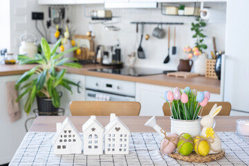 Key to house of cozy home with Easter decor with rabbit and eggs on table of kitchen. Building,...