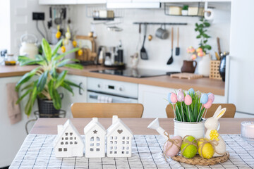 Key to house of cozy home with Easter decor with rabbit and eggs on table of kitchen. Building, design, project, moving to new house, mortgage, insurance, rent and purchase real estate