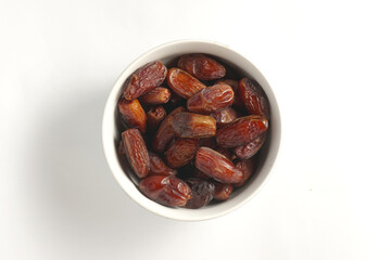 a bowl filled with a collection of dates with a plain white background