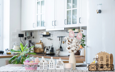 Key to house of cozy home with Easter decor with rabbit and eggs on table of kitchen. Building, design, project, moving to new house, mortgage, insurance, rent and purchase real estate