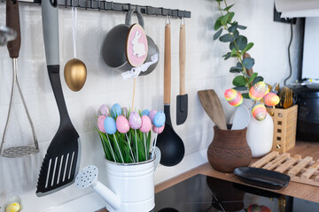 Interior of kitchen and details of decor of utensils with Easter decoration of colorful eggs in a...