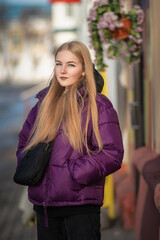 Portrait of a young beautiful fair-haired girl on a spring street.