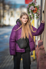 Portrait of a young beautiful fair-haired girl on a spring street.