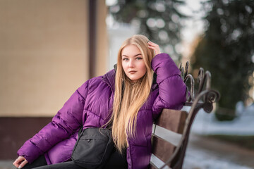 Portrait of a young beautiful fair-haired girl on a spring street.