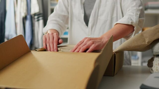 Packing, Business woman Busily packing goods into a box at a packer's workplace In slow motion Young woman is in an industrial workshop Progressive business, retail
