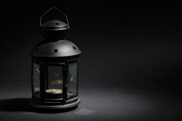 Retro Lantern with a burning candle on a dark background.