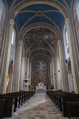 Monumental church building in Gothic in neo-romanesque arch style with large ceiling and altar murals and fresco, opulent detailed columns and marble structures