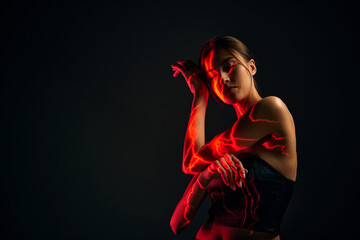 Creative portrait of young sensual woman with digital neon filter lights on body over dark mode...