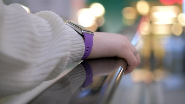 Moll. A young woman in a shopping mall stands on an escalator. 4K