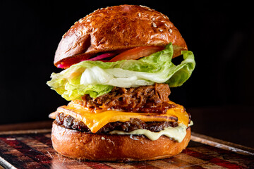 barbecue pulled beef burger with vegetables on dark background