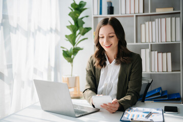 Woman freelancer is working her job on computer tablet and laptop Doing accounting analysis report...