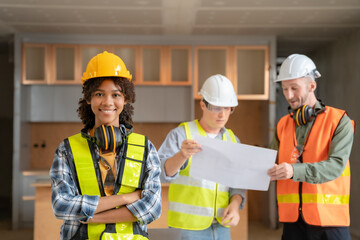 Architect colleagues mixed race working as a team discussing data working and tablet, laptop with on on architectural project at construction site at desk.