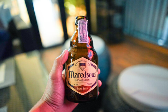 HATYAI, THAILAND - SEP 06, 2018: Man hand holding Maredsous Abbaye-Abdij Brune Beer bottle.