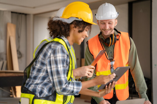 Architect colleagues mixed race working as a team discussing data working and tablet, laptop with on on architectural project.