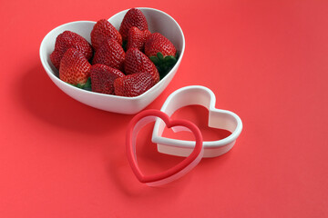 Fototapeta na wymiar Fresh strawberries in a heart-shaped bowl.