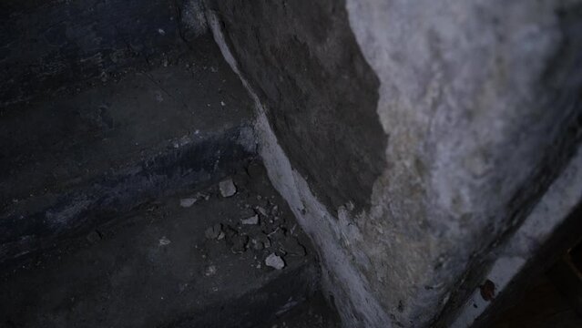 Peeling basement wall in the dark close-up. Old abandoned hideout underground