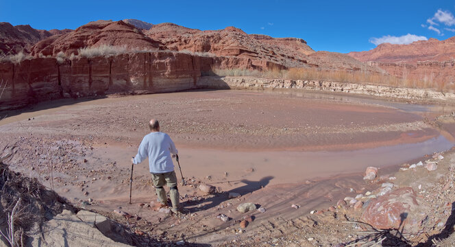 Hiker walking onto a sandbar in the Paria River, Paria Canyon, Glen Canyon National Recreation Area, Arizona, USA