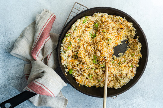 Overhead view of fried rice with onions, carrots and green bell peppers