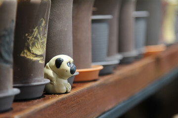 A dog clay on wooden shelve