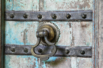 Fototapeta na wymiar An old vintage door knocker on the old wooden door